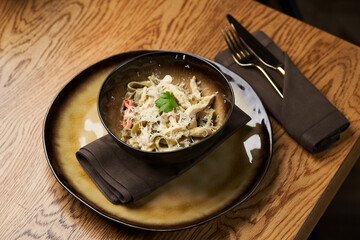 Spinach pasta salad with cheese, paprika, chicken, parsley.