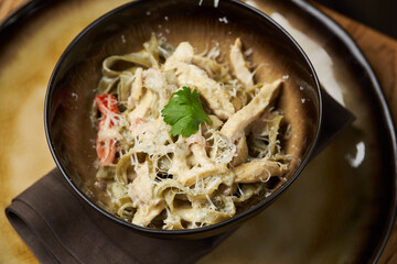 Spinach pasta salad with cheese, paprika, chicken, parsley.