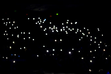 Lights and camera flash at concert, show, hall.
