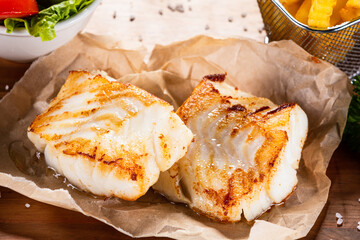 Fish dish - fried fish fillet with french fries and vegetables