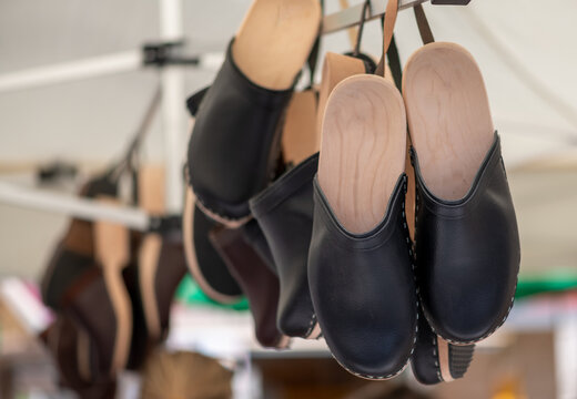 Holzcloggs h&auml;ngen an einem Marktstand