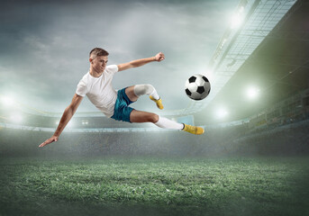 Naklejka premium Soccer player on a football field in dynamic action at summer da