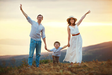 Fototapeta premium Happy family father of mother and child son on nature at sunset.