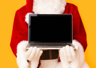 Santa Claus holding open laptop with black blank screen