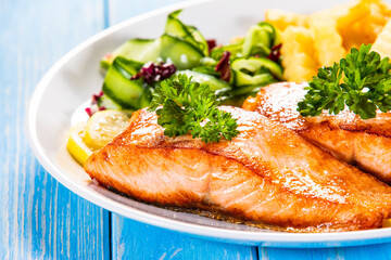 Fried salmon, French fries and vegetables