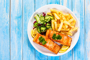 Fried salmon, French fries and vegetables