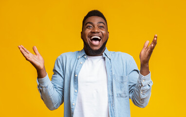 Portrait of joyful african american man raising hands in astonishment
