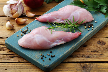 coniglio crudo intero e porzionato su tavolo di cucina