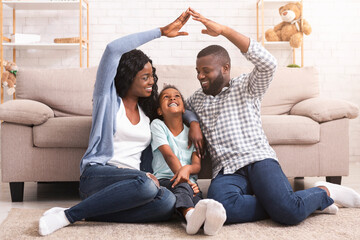 Black family making symbolic roof of hands above little girl