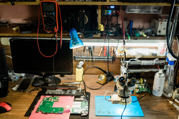 Workplace of repairman with details of demounted gadgets other supplies