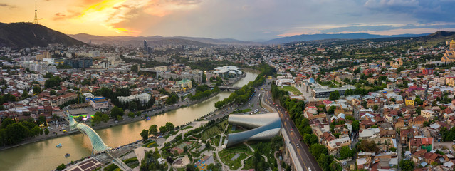 The old town in the old district of Avlabari, Holy Trinity Cathedral and Rike Park, the Kura river reflects the evening city lights and cars traffic with blure in Tbilisi, Georgia