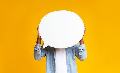 African american man hiding face behind empty speech bubble