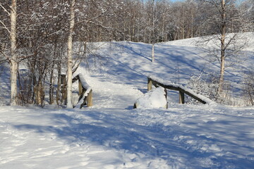 Small wooden bridge in a snowy park