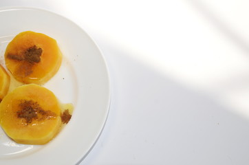 Vegetarian Diet Food. On a white plate are slices of baked pumpkin with honey and cinnamon.