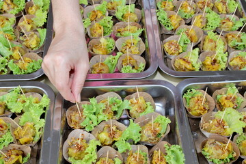 Shumai or Chinese steamed dumpling with lettuce in dry banana leaf on stainless steel tray prepare cocktail style for party.