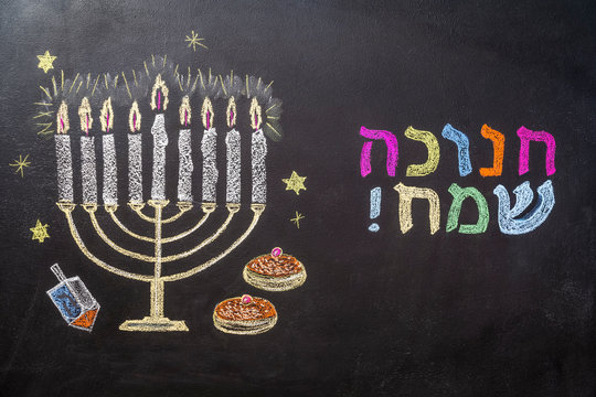 Menorah, dreidel and sufganiyot on chalkboard. Hanukkah holiday illustration. View from above.