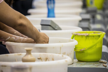 Chinese children modeling clay pots. Hands close-up.