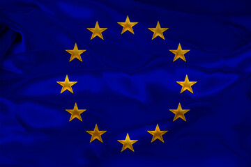 close-up photo of beautiful colored stylized European Union flag, symbol of united Europe on textured fabric, concept of tourism, emigration, economy and politics, close-up