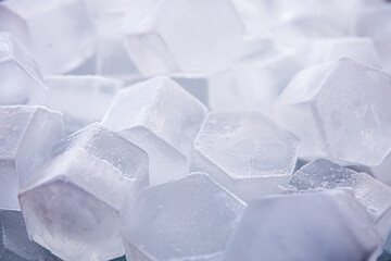 Macro shot of ice cubes from clear water that melt in slow motion on a white background. Concept: pure mountain spring water, ice, cocktails, fresh and frozen foods.