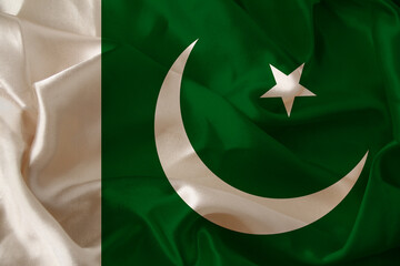 photo of the beautiful colored national flag of Pakistan state on a textured fabric, concept of tourism, economics and politics, closeup, copy space