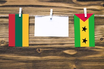 Hanging flags of Lithuania and Sao Tome And Principe attached to rope with clothes pins with copy...
