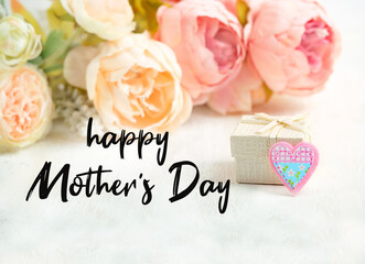 Obraz premium Happy Mother's Day greeting card. Holiday season concept, festive design. gift box and pink flowers for mom. 