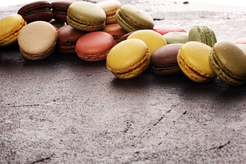 Sweet and colourful french macaroons or macaron on dark black background, Dessert.