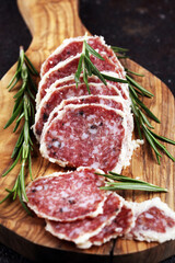 Salami truffle. The saltufo is a piece of salami mixed with summer truffle on rustic background