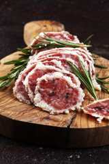 Salami truffle. The saltufo is a piece of salami mixed with summer truffle on rustic background