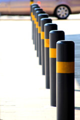 Row of black restrictive posts with yellow reflectors