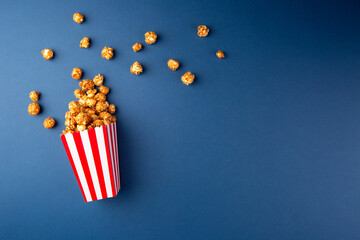 Cinema concept. Caramel popcorn on blue background