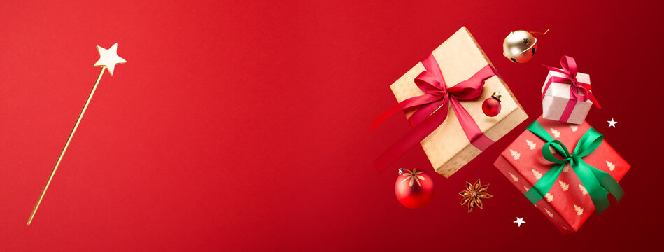 Happy New year concept. Christmas gifts, decorations and toys fly or fall in the air on a red background.