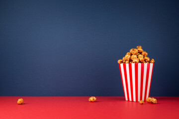 Cinema concept. Caramel popcorn on blue and red background