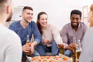 Excited friends talking and eating pizza at home