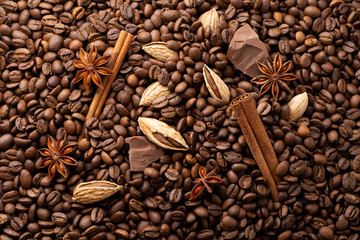 Cinnamon, chocolate, anise and almonds on coffee beans background