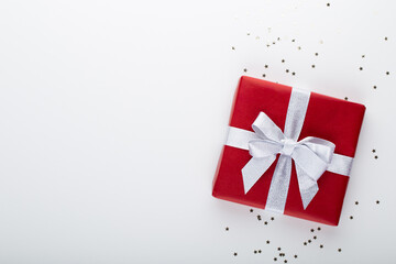 Gift or present box and stars confetti on color table top view. Flat lay composition for birthday, mother day or wedding.