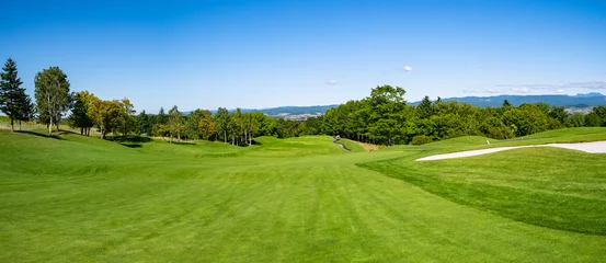 Tuinposter Golfbaan met prachtig groen veld. Golfbaan met een rijke groene grasmat prachtig landschap. © okimo