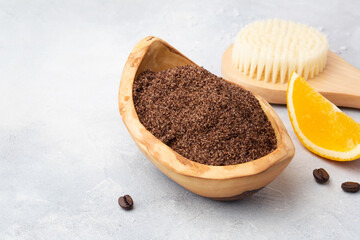 Beautiful spa relax concept. Coffee and orange scrub and brush for body massage on grey background.