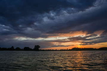 Dark clouds over the lake at sunset