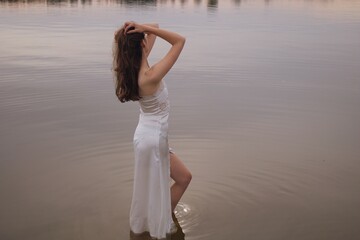 Fototapeta na wymiar young woman in white dress on the beach
