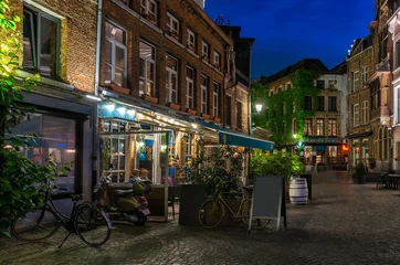 Poster Oude gezellige smalle straat met tafels van restaurant in het historische centrum van Antwerpen (Antwerpen), België. Nacht stadsgezicht van Antwerpen. Architectuur en herkenningspunt van Antwerpen © Ekaterina Belova
