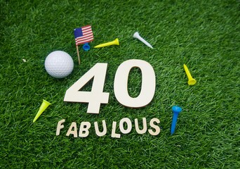 40th and Fabulous golfer with number forty and golf ball are on green grass with tee