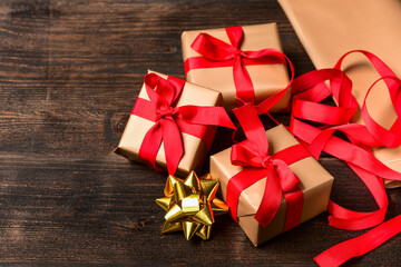 Christmas 2020 New Year 2020 Saint Valentine gift wrapping. Golden beige paper and red bow on a wooden table, family holiday. celebration atmosphere . Xmas spirit present