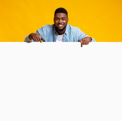 Black man leaning on white board and pointing on it