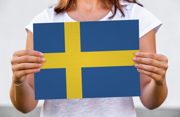 woman holds flag of Sweden on paper sheet