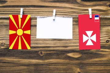 Hanging flags of Macedonia and Wallis And Futuna attached to rope with clothes pins with copy space...