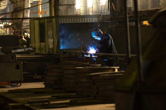 Worker In The Shop Performs Welding