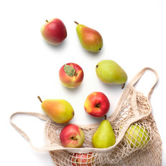 Ripe apples and pears in eco cotton string bag and on white