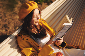 Girl resting in a hammock in the park.Girl in a yellow beret.