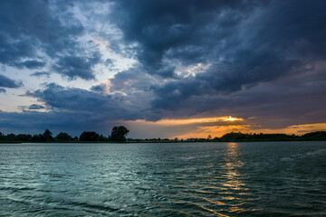 Naklejka premium Colorful clouds during sunset on the lake